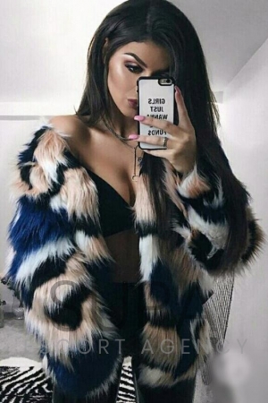 Cara wearing fur coat taking selfie with her iPhone 