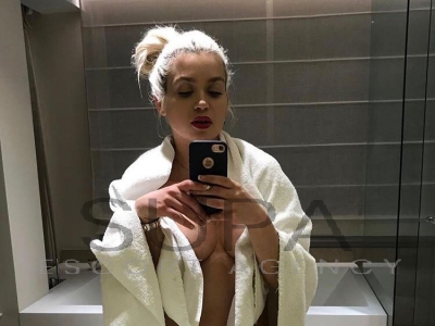 Naomi taking selfie in bathroom mirror with iPhone