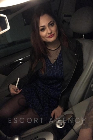 Teo in blue dress sitting in car seat